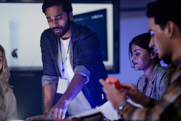 Fototapeta premium An Indian engineer presents an AI powered prosthetic arm in an RD lab. Her team, including a Caucasian woman, analyzes the robotic prototype and its data on a screen.