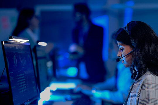 Data analyst deep dive night shift analyzing complex metrics visualizations dashboard screen headset facilitates remote team collaboration insights extraction critical business intelligence.