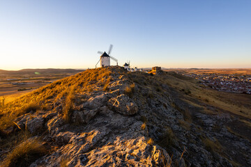 Obraz premium Consuegra windmills and castle at sunset