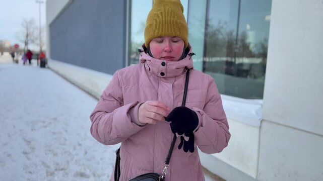 Woman outside in winter uses moisture lipstic fot the dry dry lips