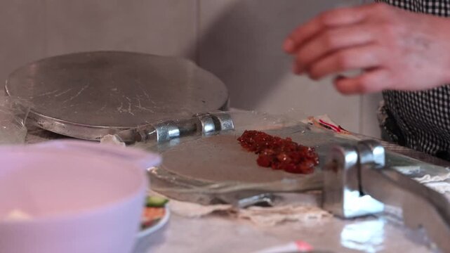 Woman's hands preparing a traditional Mexican molote with tinga filling