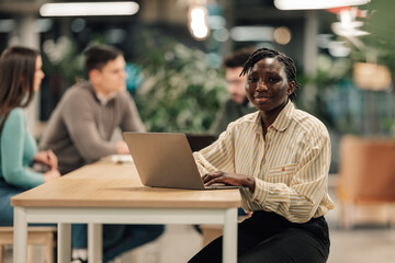 Obraz premium African american woman working on laptop in modern office