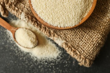 Close-up view of fine semolina flour in a wooden bowl and spoon on burlap