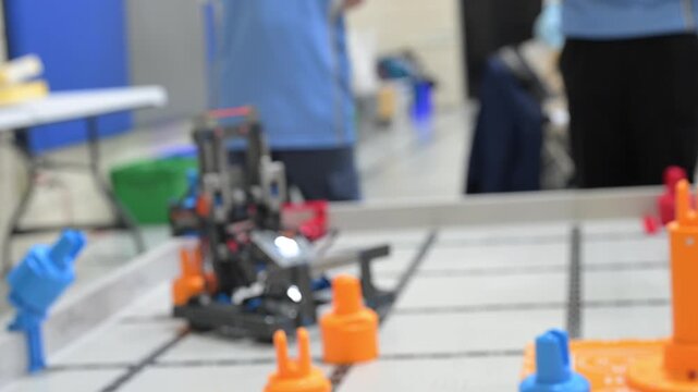 Defocused Students participate in a robotics competition and present their projects in a gym on a Saturday afternoon