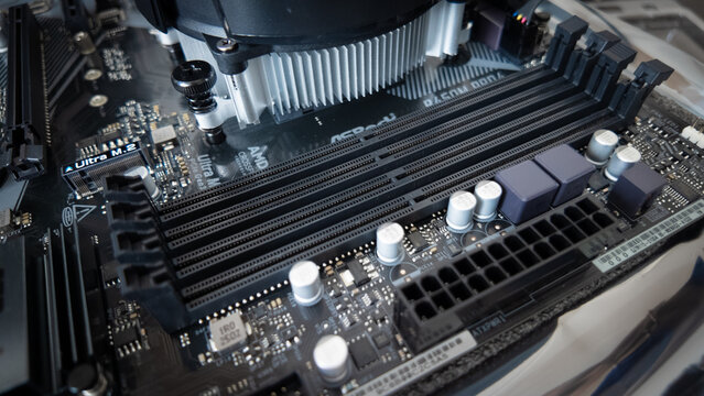 Motherboard with four empty RAM slots during PC assembly, illustrating increased memory costs and delayed component upgrades.
