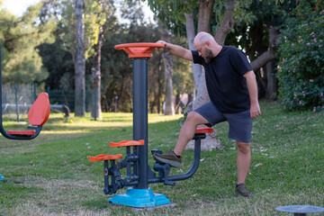 Man Using Outdoor Fitness Equipment in Public Park. Healthy Lifestyle Exercise in City Park. Man Training on Outdoor Gym Equipment. Public Park Fitness Equipment Workout.