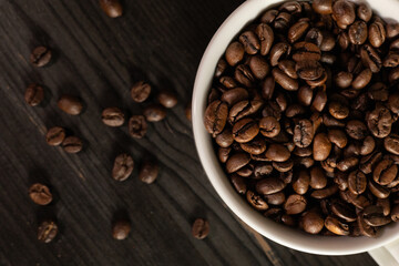 Fototapeta premium White coffee cup filled with coffee beans, minimal still life, clean background, coffee concept.