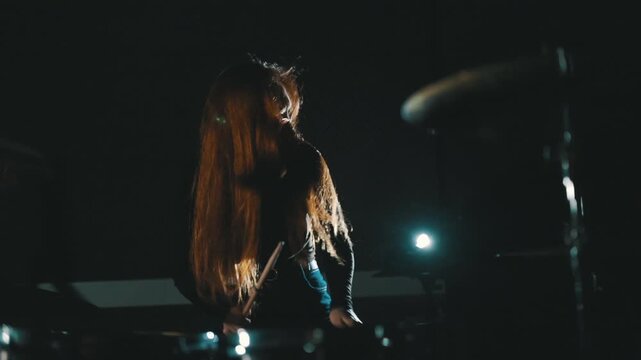Female drummer playing energetic rock music