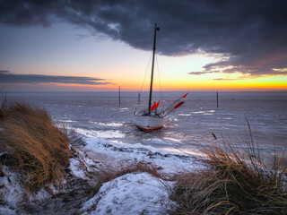 Frozen water on the Bay of Puck in Kuznica on the Hel Peninsula at sunset. Poland