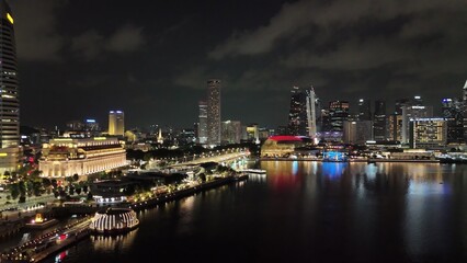 Aerial drone view of Singapore night light show with vibrant skyline and reflections