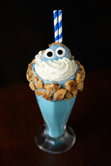 A blue drink with cookie crumbs and a blue cookie monster on top © Harry