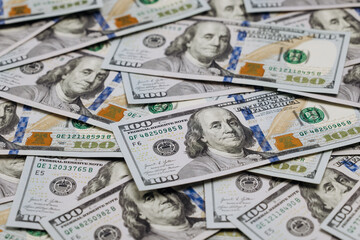 Fototapeta premium Close-up view of multiple one hundred dollar bills stacked together, showcasing intricate details of currency design and security features on a flat surface