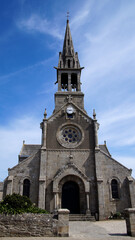 Obraz premium Frontal view of a church with a distinctive tower and entrance under a blue sky, showcasing symmetrical historical architecture.