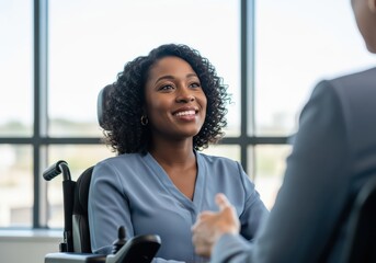 Smiling woman in wheelchair in business meeting, discussing ideas with colleague