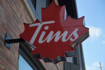 Naklejka premium close-up of projecting maple leaf sign outside Tim Hortons, a coffee shop, located at 408 Roncesvalles Av, at Howard Park Av, Toronto