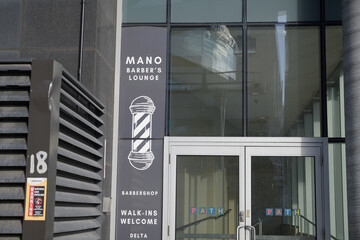 Naklejka premium MANO Barber's Lounge sign outside entrance to Delta hotel at 75 Lower Simcoe St, Toronto
