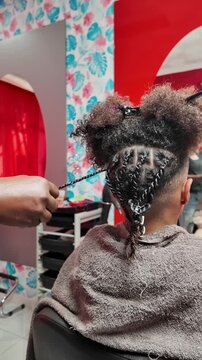 Rear view of teen boy&rsquo;s afro with fully finished braid, showing most of the back completed