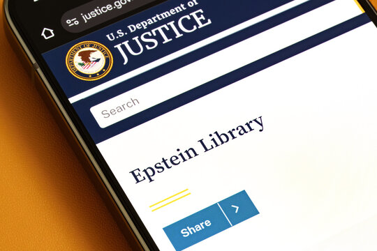 Epstein Library page on U.S. Department of Justice website displayed on smartphone screen with search bar and DOJ seal in close-up. Stafford, United Kingdom, February 1, 2026,