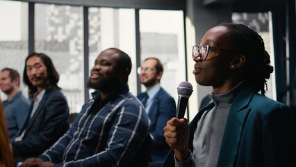 Obraz premium Diverse group audience applauding and greeting speaker during discussion. Multiethnic white collar workers and executives attend international event, meeting in conference hall.