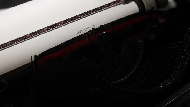 Vintage typewriter printing the word love repeatedly on a white sheet, conveying concepts of romance, communication, and classic sentiment with a retro aesthetic