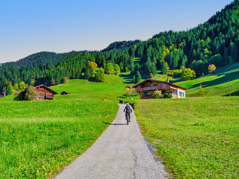 Mountain Biker Riding Uphill on Alpine Road in Triesenberg