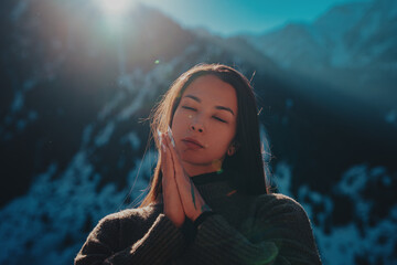 Young woman spiritual portrait in high snowy mountains on winter day