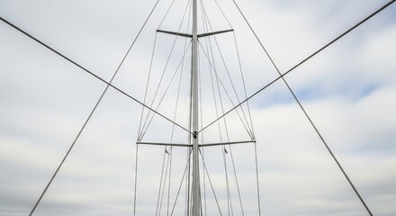 Fototapeta premium Sailboat mast and rigging against cloudy sky, a view from below for nautical adventure and marine travel concept