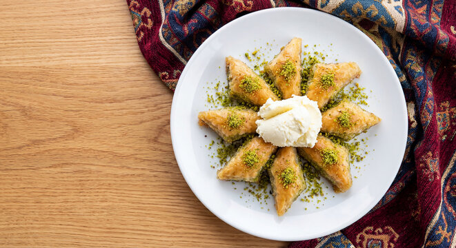Traditional Middle Eastern Basbousa Semolina Cake with Cream and Pistachios on Decorative Plate