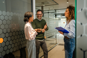Diverse business team collaborating in modern office hallway
