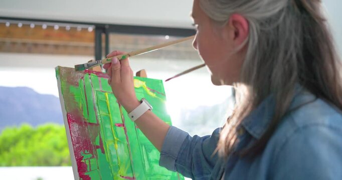 Brushes are tapping across canvas on contact near sliding doors, adding green accents, refining art