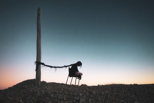 Woman on chair abstract surreal portrait depicting sadness self doubt depression horror hair silhouette mental health struggle creative concept self-doubt surreal portrait darkness fantasy tied back 