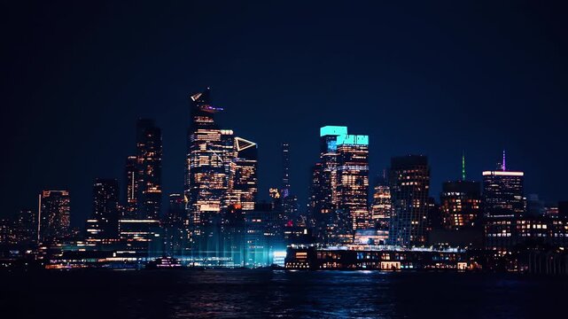 Midtown Manhattan skyline at night. Midtown Manhattan skyscrapers glow with city lights against a dark night sky.