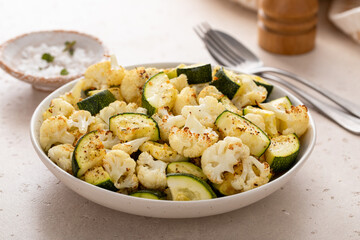 Roasted cauliflower and zucchini with garlic and herbs in a serving bowl
