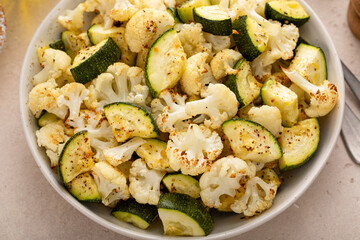 Roasted cauliflower and zucchini with garlic and herbs in a serving bowl