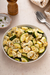 Roasted cauliflower and zucchini with garlic and herbs in a serving bowl