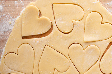 Making heart shaped cookies for Valentines day, cut out vanilla cookies