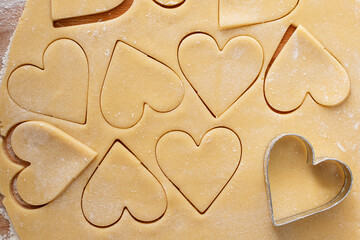 Making heart shaped cookies for Valentines day, cut out vanilla cookies