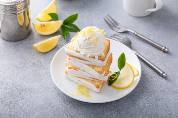 Lemon pound cake with sugar frosting sliced on plates served with whipped cream