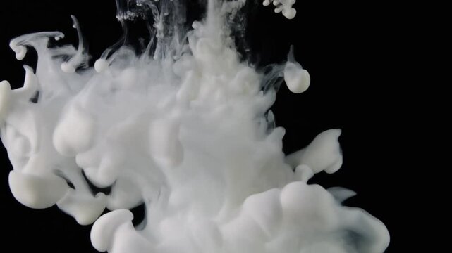A beautiful white milk splash explodes like an abstract cloud of steam and bright ice against an isolated black texture