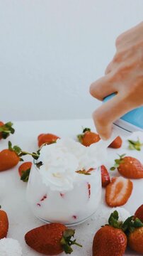 Adding Whipped Cream to Fresh Strawberry Milkshake in Glass