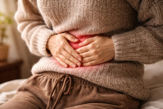 Stomach pain abdominal cramp woman tummy ache period pain digestion problem hands belly cozy sweater home interior health issue Person with stomach pain abdominal cramp woman tummy ache period