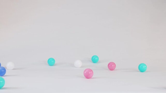 Colorful Plastic Balls Falling and Bouncing on a White Background