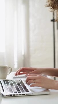 Freelancer Working on Laptop and Taking Notes in Spiral Planner at Bright Home Office
