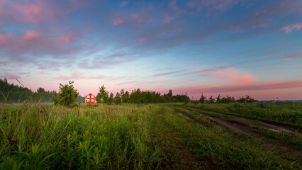 Obraz premium a beautiful summer sunrise with a house in the distance.