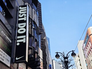 Naklejka premium Tokyo, Japan - January 15, 2026: Nike Just Do It Signage in Shibuya, Tokyo, Japan Nike is an American famous athletic footwear, was founded in January 25, 1964.