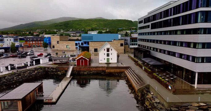 Sortland, Vester&aring;len, Norway, Cinematic drone dolly forward toward Kvitbrygga, the historic white waterfront building from 1877, beside modern harbour architecture