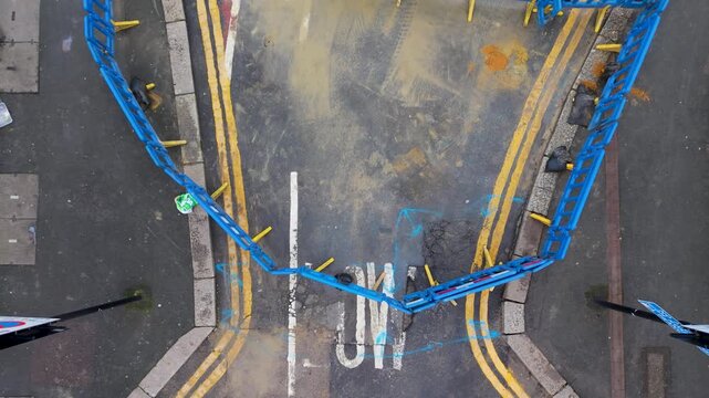 Drone rises over road barriers revealing pothole and low bridge warning