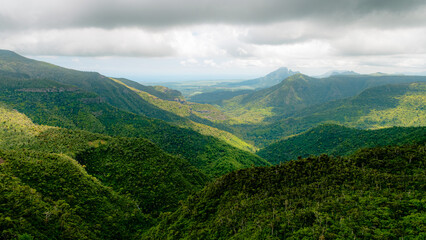 Fototapeta premium Majestic mountain range rising above lush valley landscape.