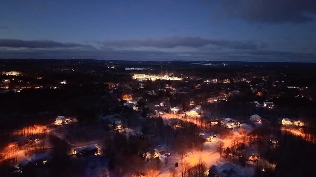 Aerial winter night view of Saint Jerome Quebec with snowy houses and glowing streets at blue hour. g.