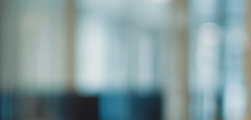 Abstract blurred office background with modern corporate interior and soft bokeh light effects creating a professional blue architectural atmosphere for business website headers. © makeeasy